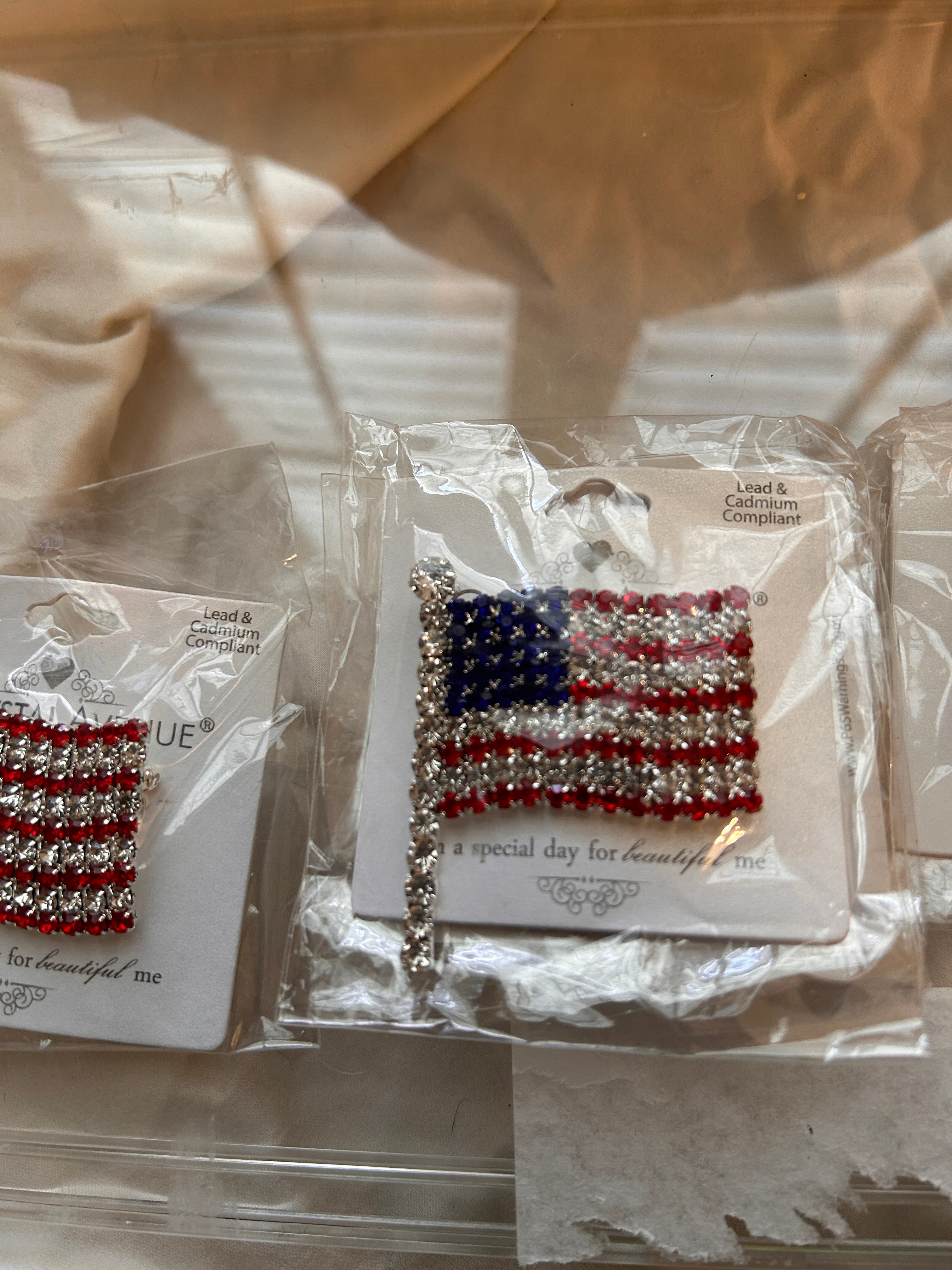 Showcase your patriotic pride with this stunning crystal rhinestone American flag pin. Dynamic waving flag design.  Mounted on a silver tone base. Fully encrusted flagpole detail for an extra touch of sophistication.  Suitable for July 4, Veterans Day, Memorial Day, or Labor Day