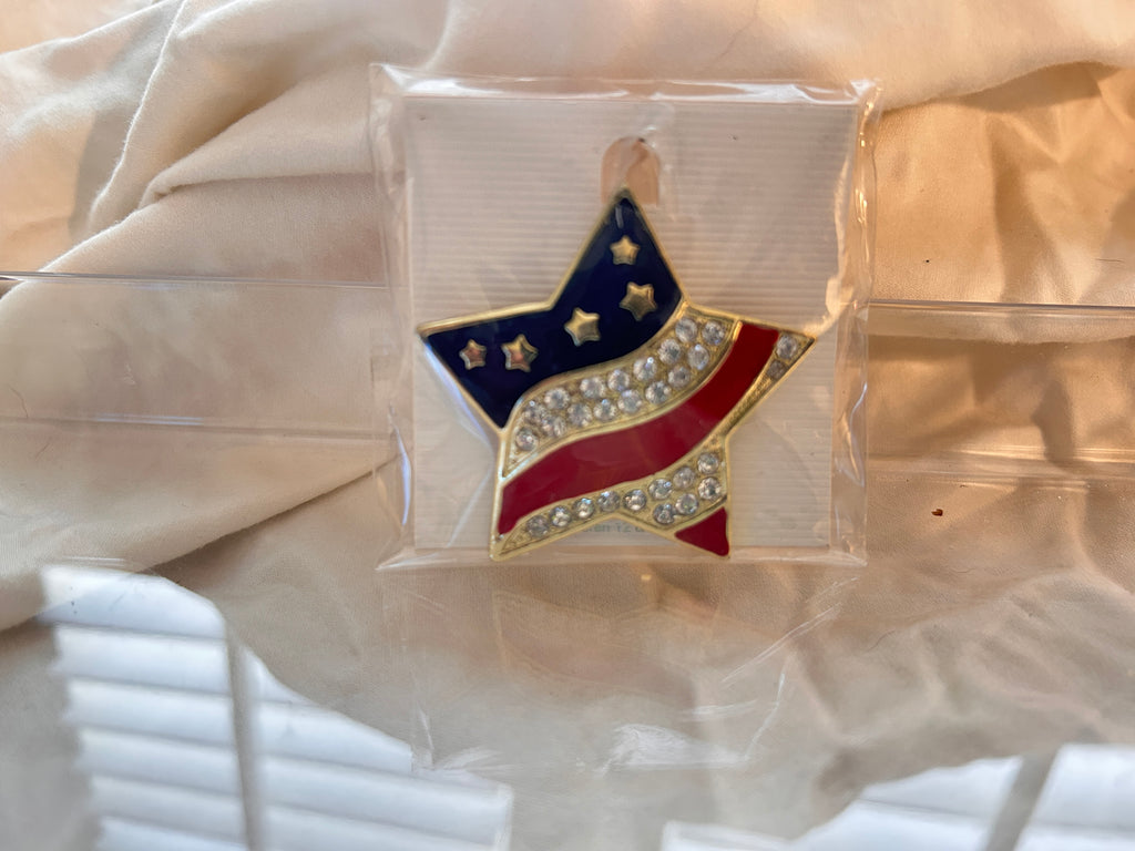 This brilliant pop of patriotism to your wardrobe. An Eye catching tribute to Old Glory. 
Good for lapels, dresses, denim jackets, hats and scarves. Dress it up or down.
Star shaped brooch featured a vibrant American flag design. Stripes encrusted with rows of shimmering clear rhinestones.  Perfect for Memorial Day, July 4, Labor Day or Veterans Day